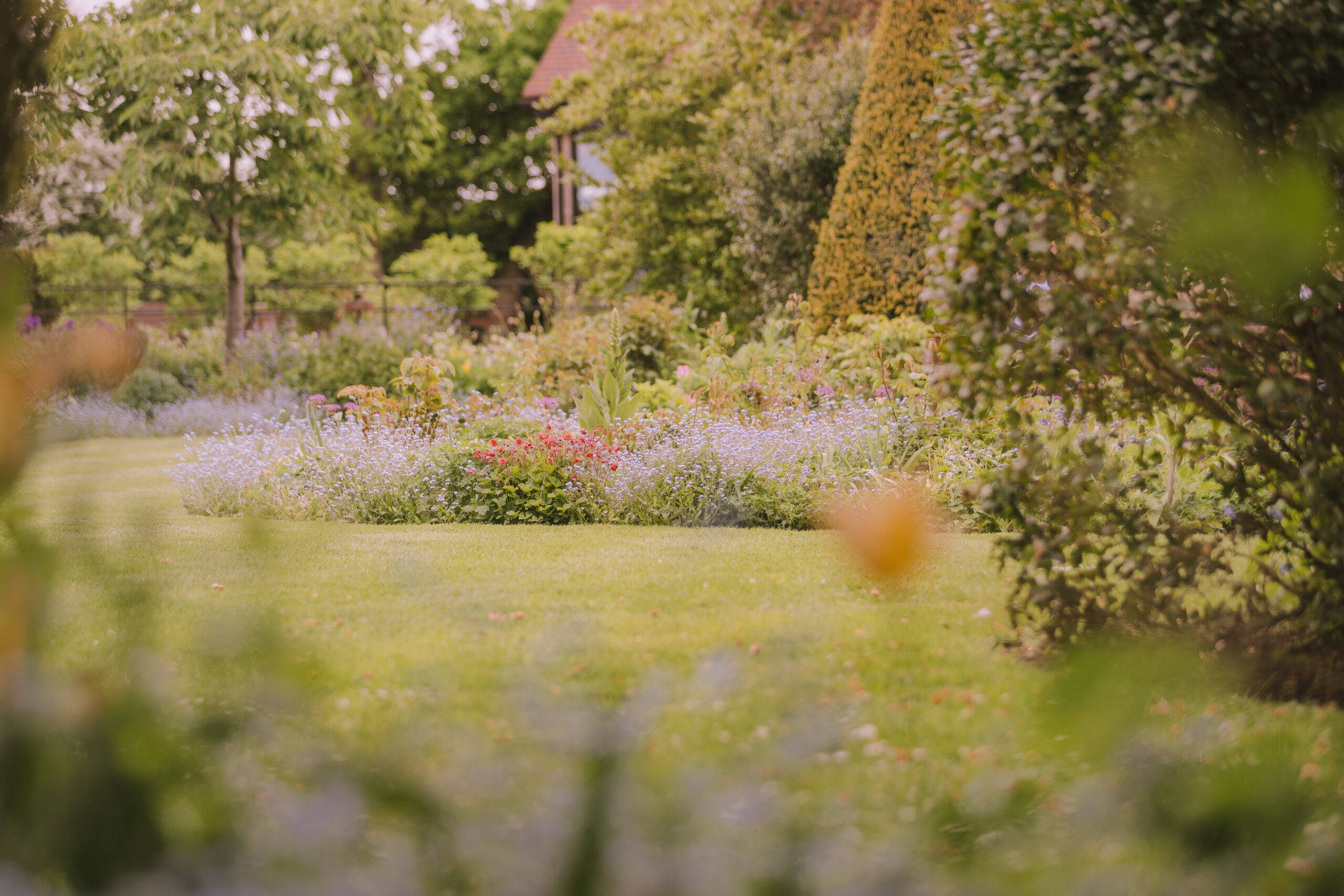Alfriston Gardens grounds with pink and lilac spring flowers