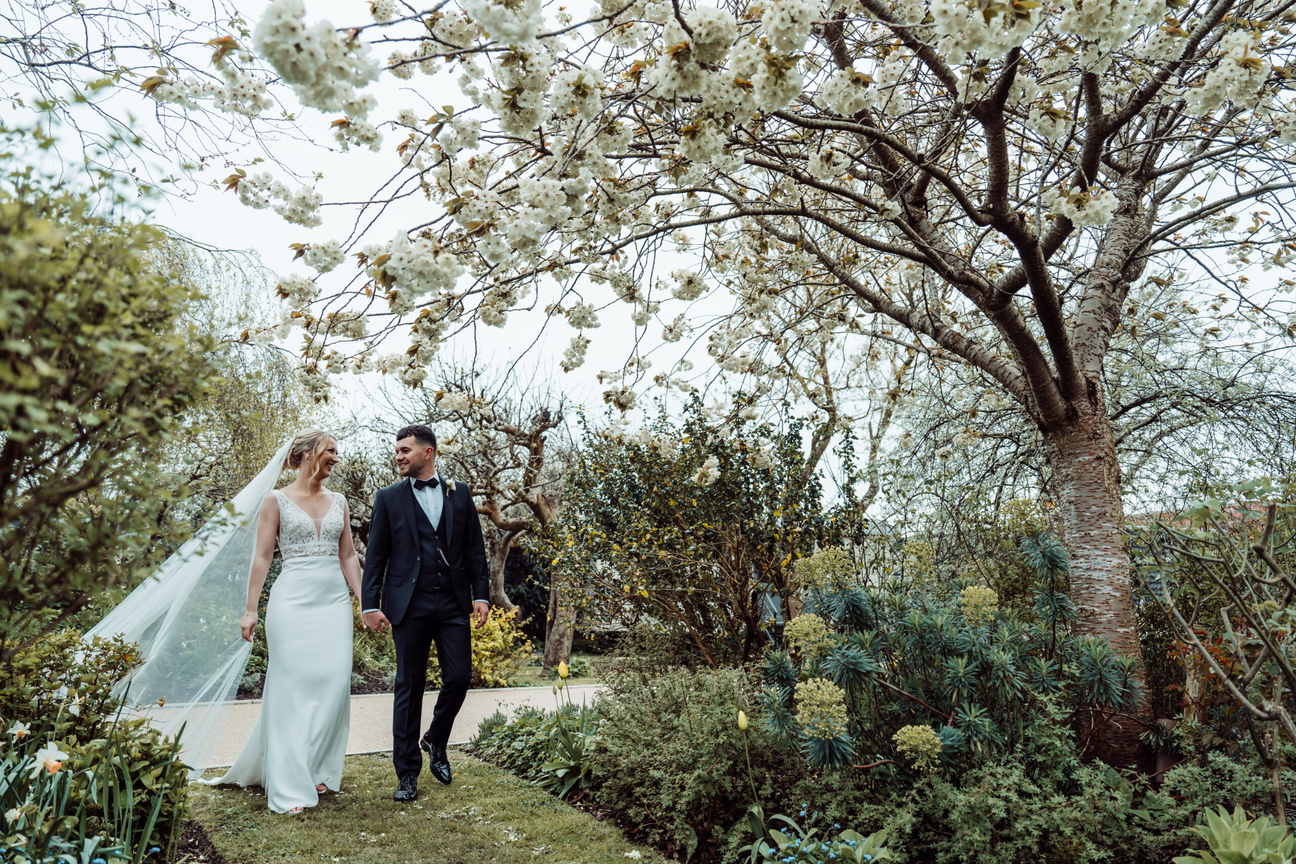 Couple walking through the landscaped grounds at Alfriston Gardens