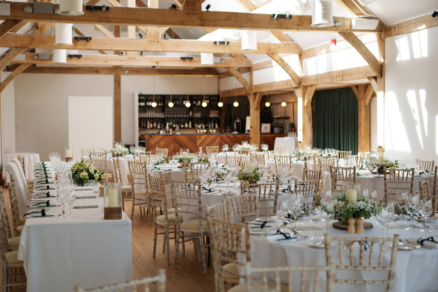 Wedding breakfast setting inside the Woodland Barn with round tables