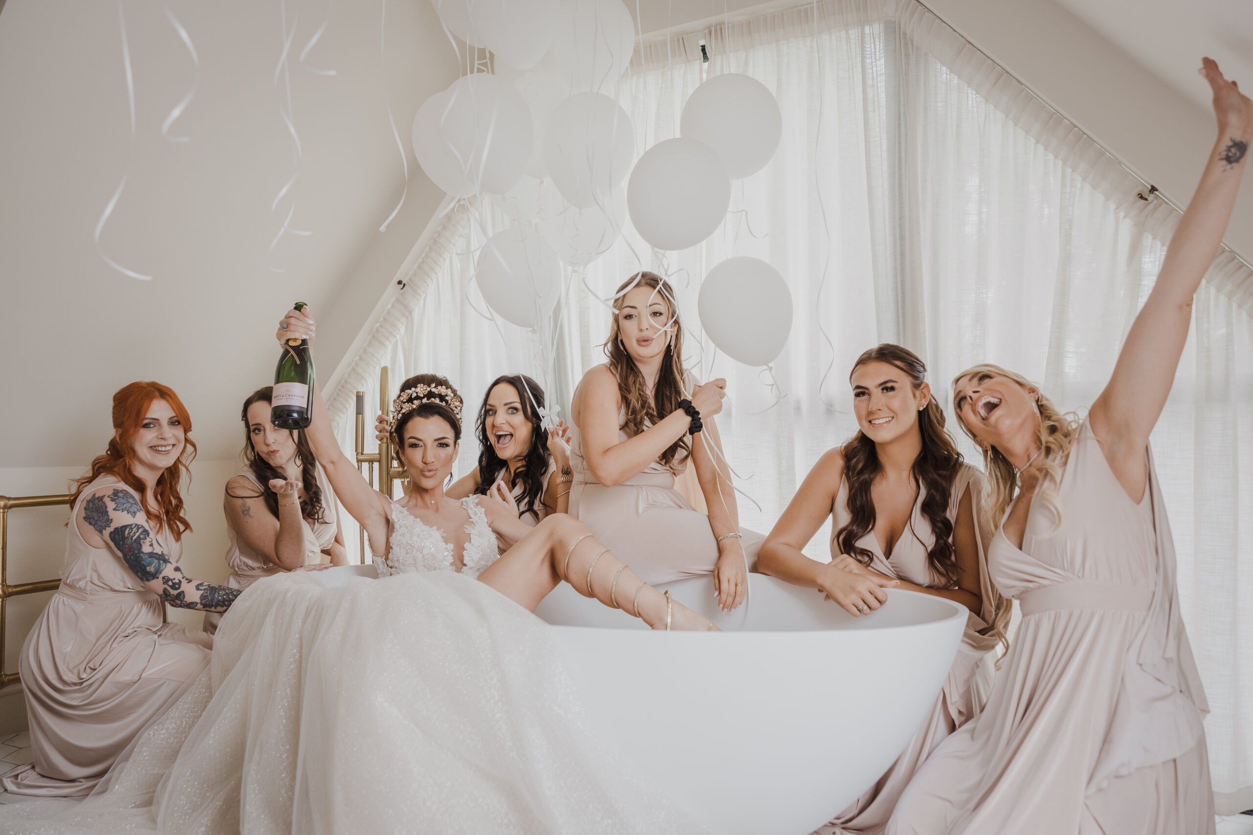 Bridal party pose in the freestanding bath within Lavender Lodge