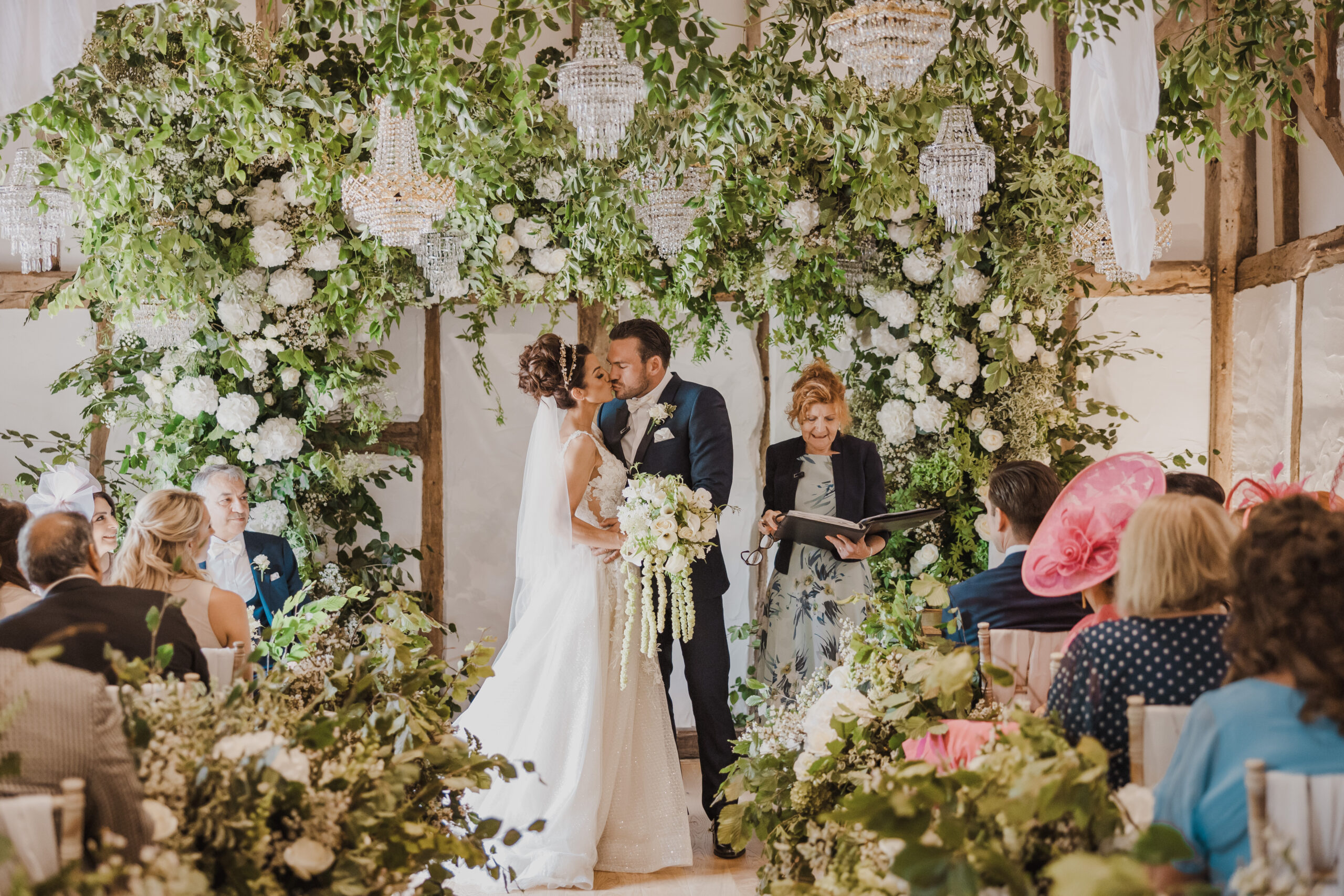 Bride and groom kiss during wedding ceremony in Century Barn
