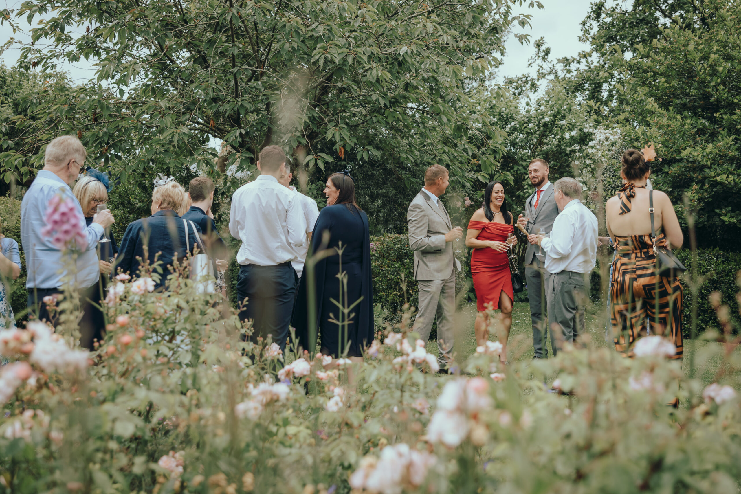 Wedding guests socialising in the grounds of Alfriston Gardens